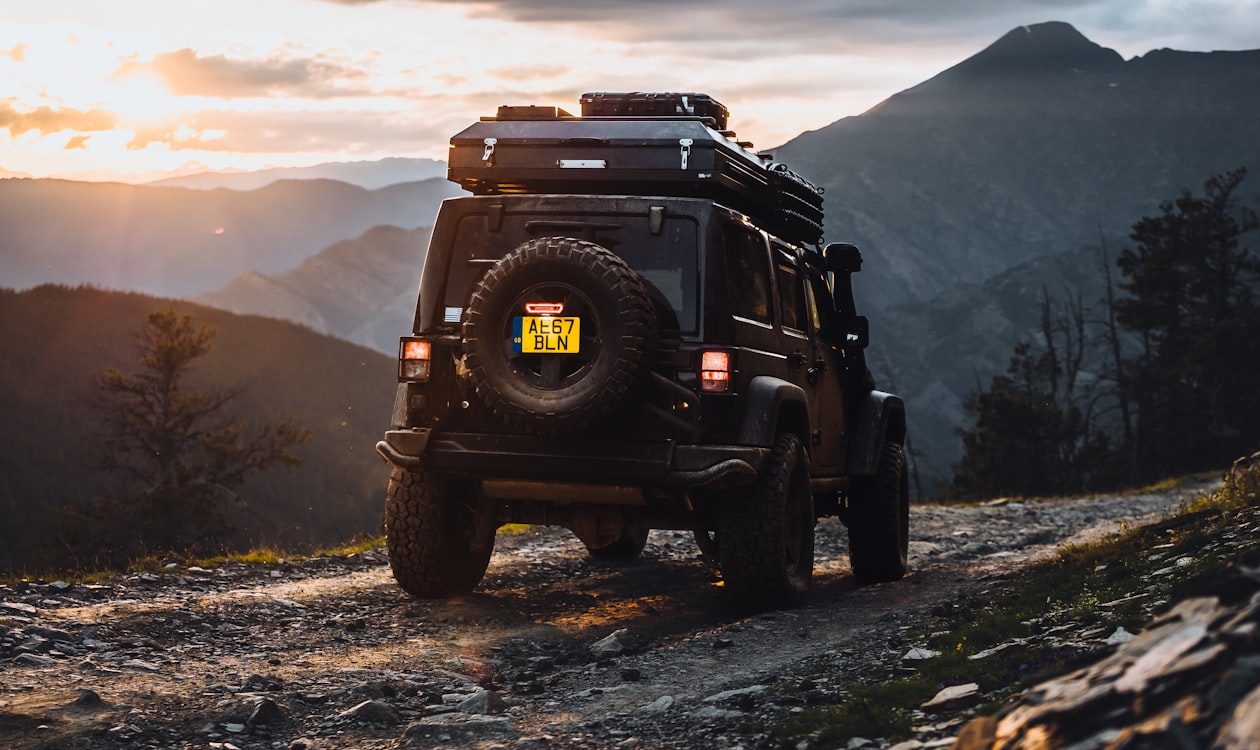 Jeep Wrangler Rubicon on an alpine mountain trail at sunset